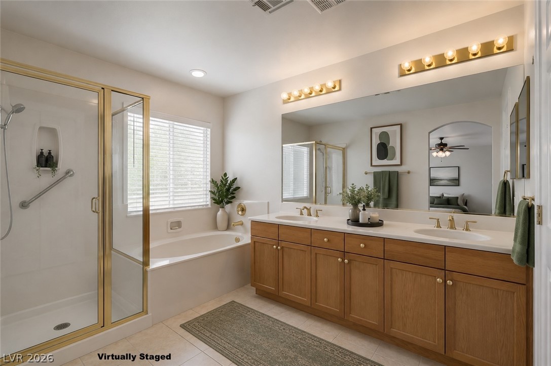 1479 Orange Jubilee Road Henderson, NV 89014 - Photo 20 of 36 Indulge in this well-lit primary bathroom featuring a spacious dual vanity and a deep soaking tub.