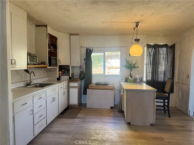 a kitchen with sink cabinets and wooden floor