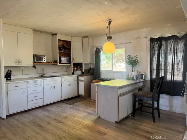 a kitchen with wooden cabinets a sink a stove and a wooden floors