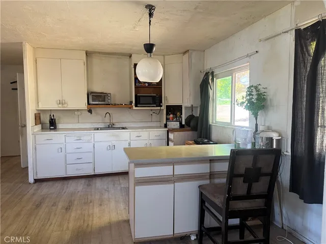 a kitchen with a table chairs sink and cabinets