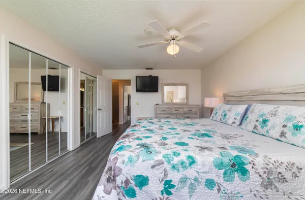 a bedroom with a large bed and a chandelier