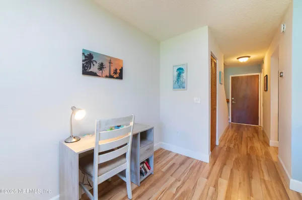 a view of a hallway with wooden floor and furniture