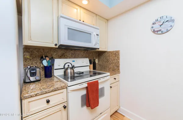 a kitchen with granite countertop a sink and a stove