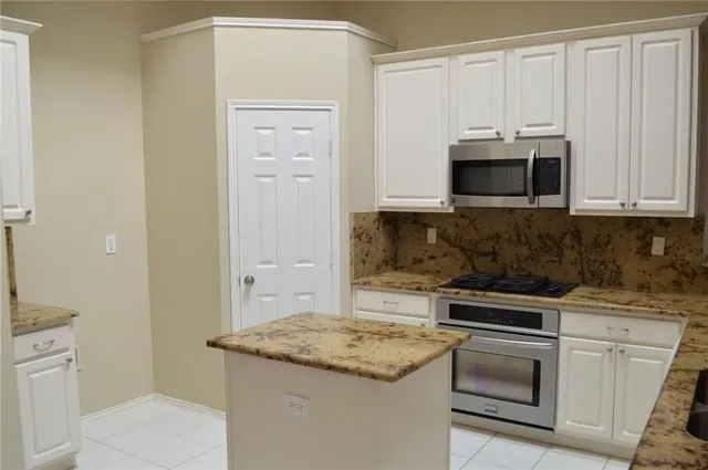 a kitchen with granite countertop a sink and cabinets
