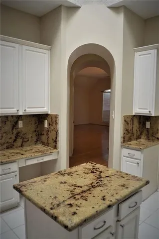 a view of kitchen island with granite countertop sink