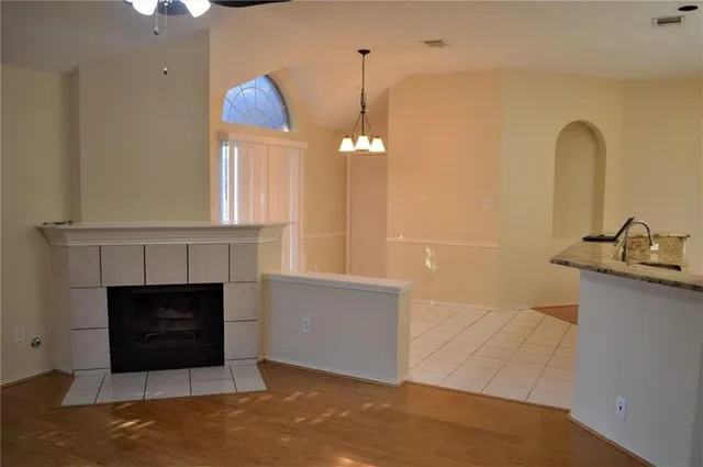 a hallway with a fireplace and chandelier