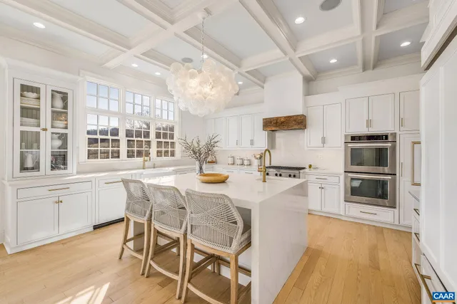 a living room with furniture chandelier and a large window