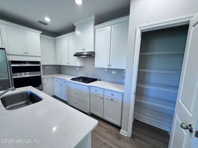 a kitchen with granite countertop a cabinets and stainless steel appliances