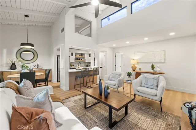 a living room with furniture a rug and kitchen view