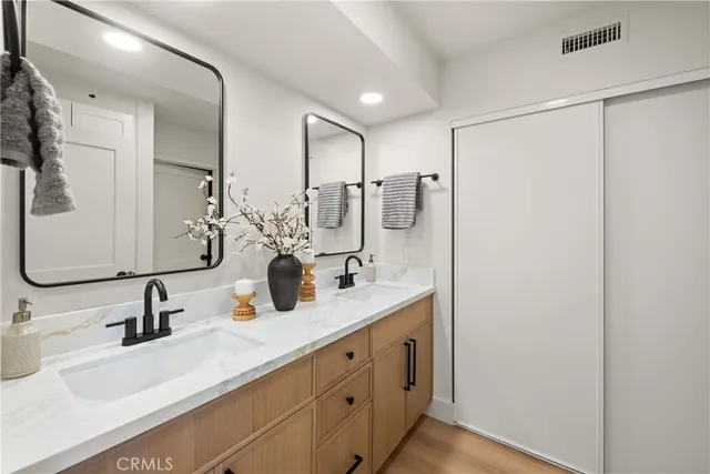 a bathroom with double vanity sink and a mirror