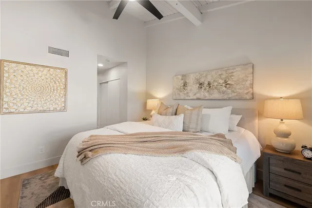 a bedroom with a bed and painting on the wall