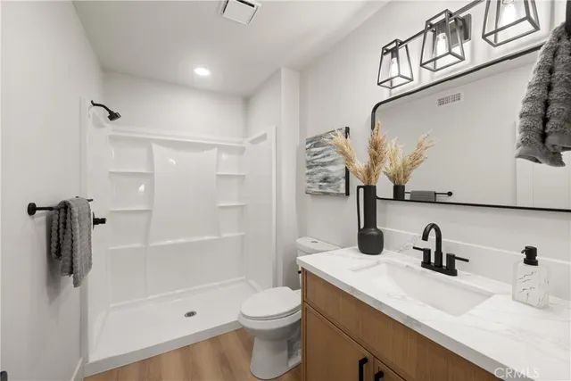 a bathroom with a sink a toilet and shower