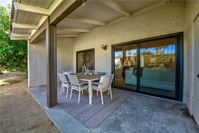 a view of a porch with furniture and floor to ceiling window