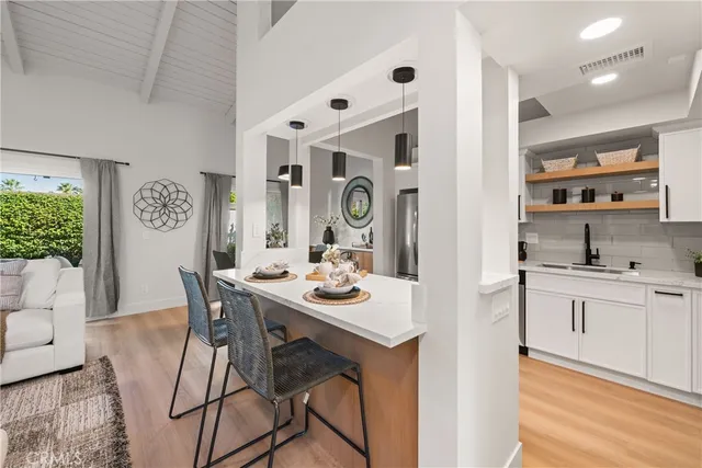 a view of a kitchen area with furniture and wooden floor