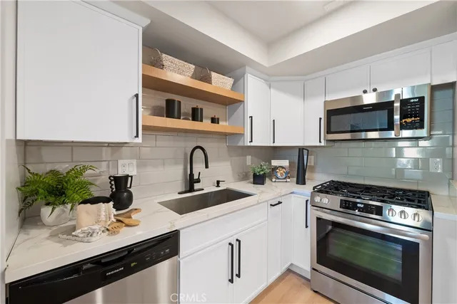 a kitchen with appliances a sink cabinets and a microwave