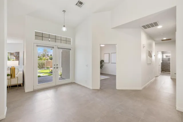 a bathroom with a double vanity sink a large mirror and a bathtub
