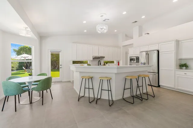 a kitchen with white cabinets and window