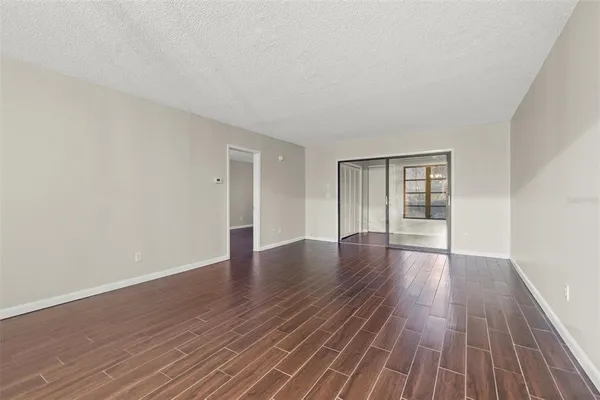 a view of an empty room with wooden and a window