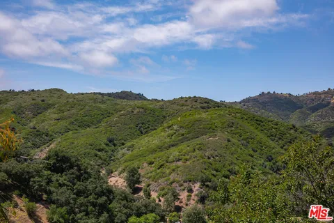 a view of a mountain range with lush green forest