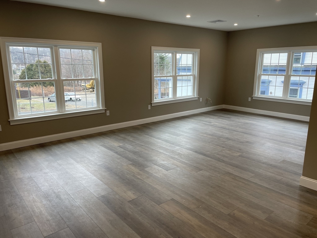 1 Brattle Street, Unit 3 Worcester, MA 01606 - Photo 3 of 21 an empty room with wooden floor and windows