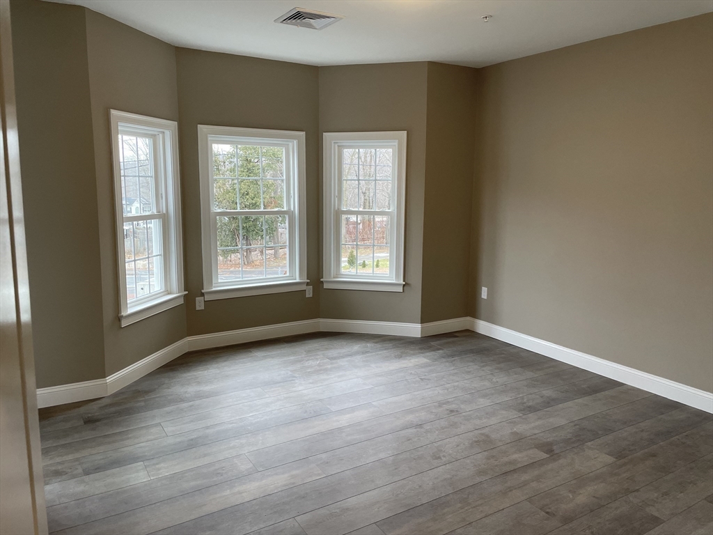 1 Brattle Street, Unit 3 Worcester, MA 01606 - Photo 10 of 21 an empty room with wooden floor and windows