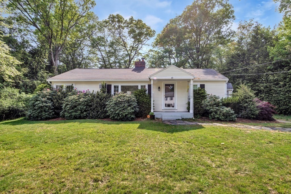 a front view of a house with a yard and trees