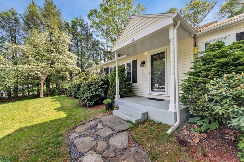 49 Woodland Road Ashland, MA 01721 - Photo 2 of 36 a view of a white house with a yard and potted plants
