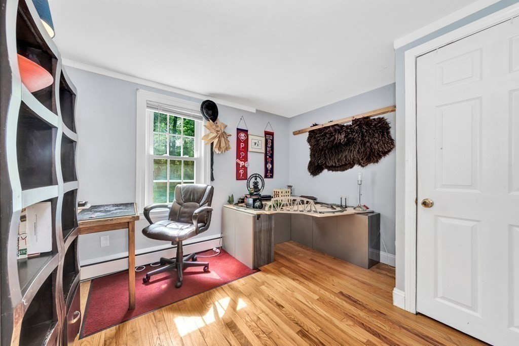 49 Woodland Road Ashland, MA 01721 - Photo 22 of 36 a living room with furniture a flat screen tv and floor to ceiling window