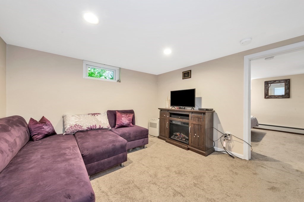 49 Woodland Road Ashland, MA 01721 - Photo 29 of 36 a living room with furniture and a flat screen tv