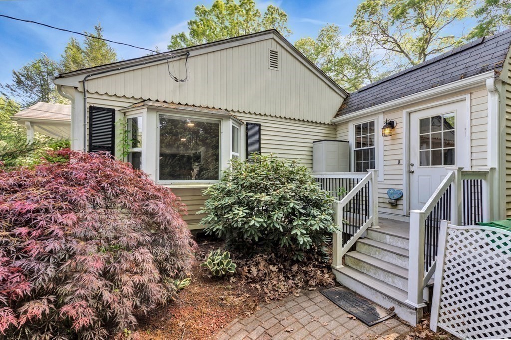49 Woodland Road Ashland, MA 01721 - Photo 33 of 36 a view of a white house with wooden walls and potted plants