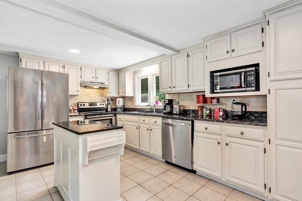 49 Woodland Road Ashland, MA 01721 - Photo 4 of 36 a kitchen with white cabinets and stainless steel appliances