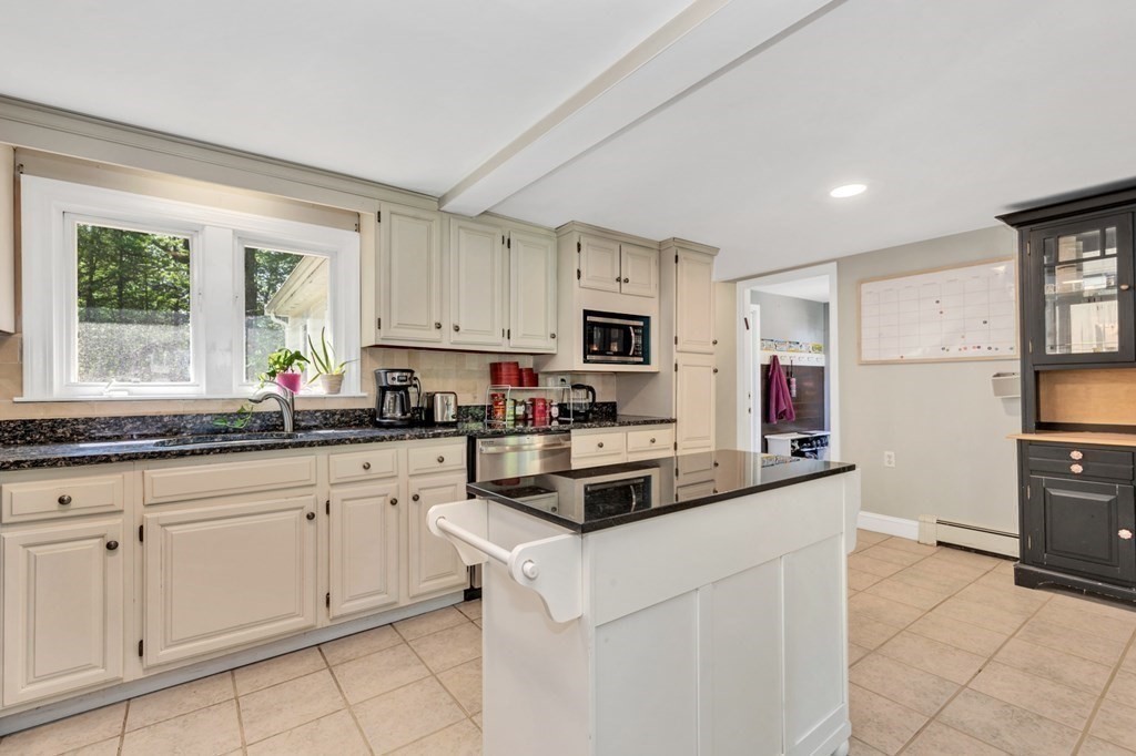 49 Woodland Road Ashland, MA 01721 - Photo 5 of 36 a kitchen with granite countertop white cabinets and white appliances