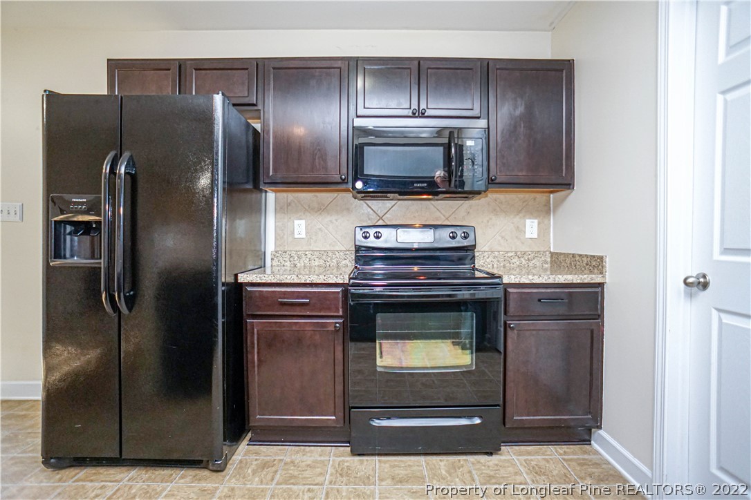 286 Cape Fear Road Raeford, NC 28376 - Photo 13 of 46 a kitchen with stainless steel appliances granite countertop a refrigerator and a stove