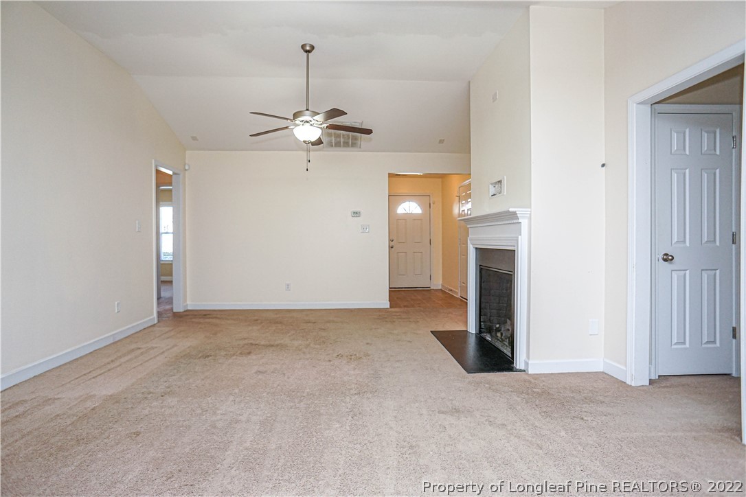 286 Cape Fear Road Raeford, NC 28376 - Photo 6 of 46 an empty room with a fireplace and chandelier fan