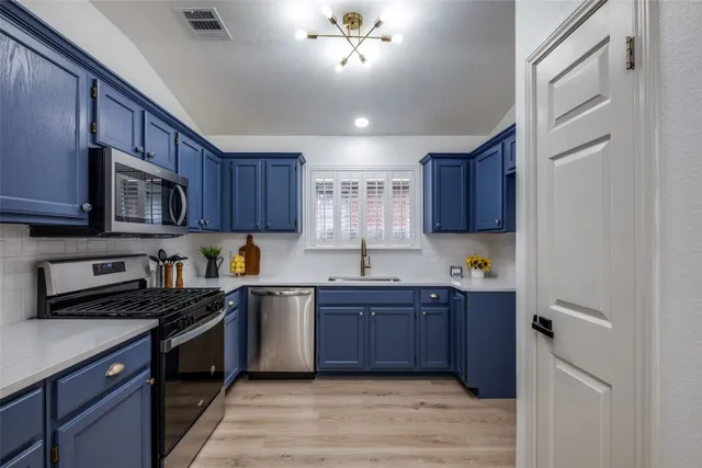 a kitchen with stainless steel appliances granite countertop wooden cabinets a stove top oven a sink and dishwasher
