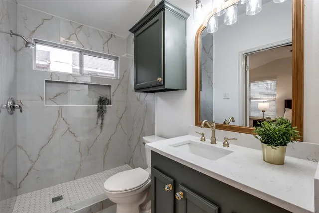 a bathroom with a granite countertop sink toilet and shower