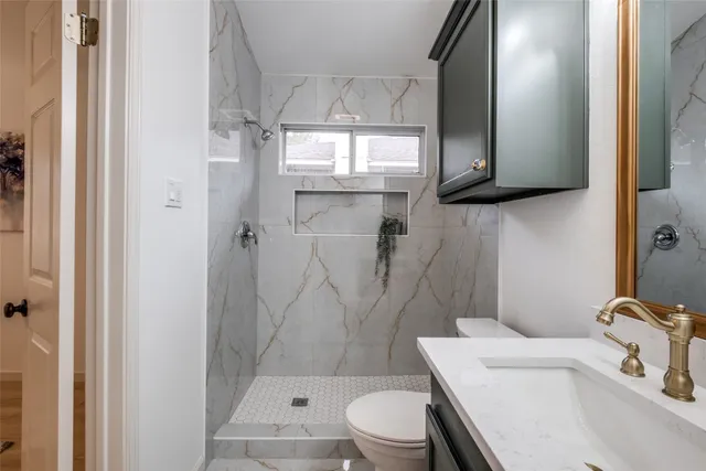 a bathroom with a sink a toilet and shower