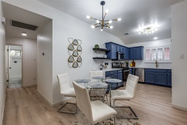 a view of a dining room with furniture a chandelier and wooden floor
