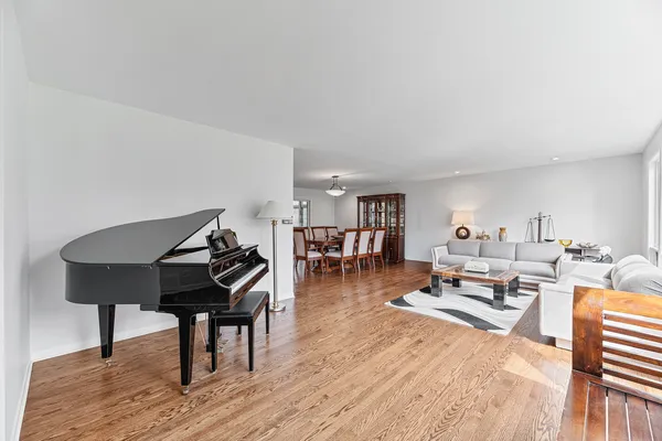 a living room with furniture a table and wooden floor