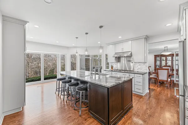 a kitchen with stainless steel appliances granite countertop a sink stove and wooden floor