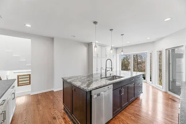 a kitchen with stainless steel appliances granite countertop a sink refrigerator and cabinets