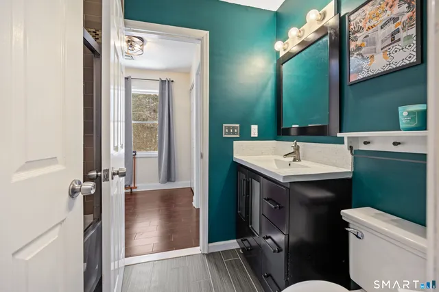 a bathroom with a sink a toilet and shower