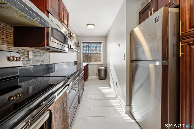 a kitchen with stainless steel appliances granite countertop a refrigerator and a stove