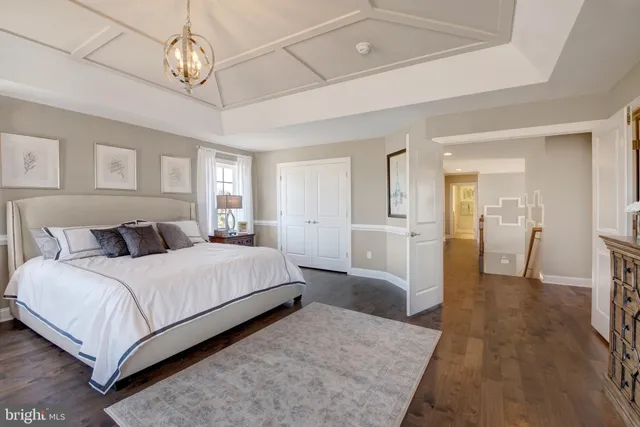 a spacious bedroom with a bed and a chandelier