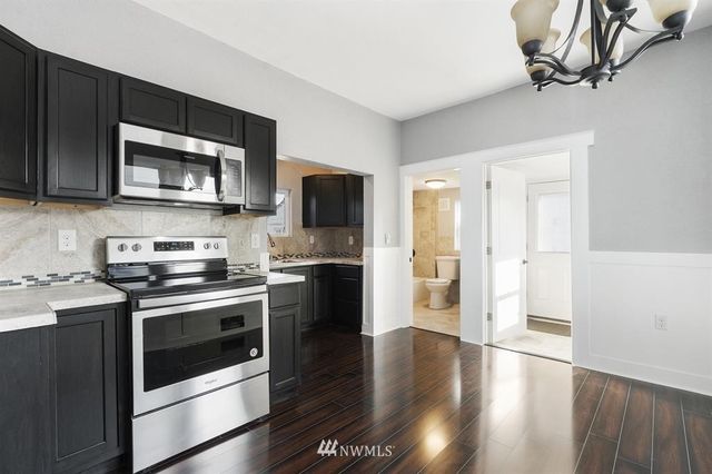 a kitchen with stainless steel appliances a stove microwave and sink