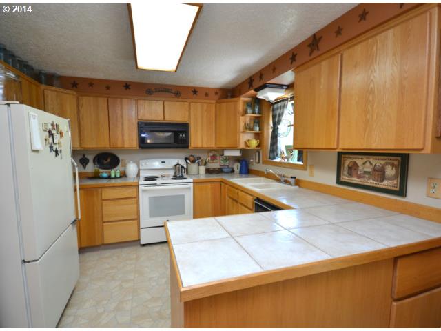 22871 South Reid Road Estacada, OR 97023 - Photo 4 of 16 a kitchen with white cabinets and a refrigerator