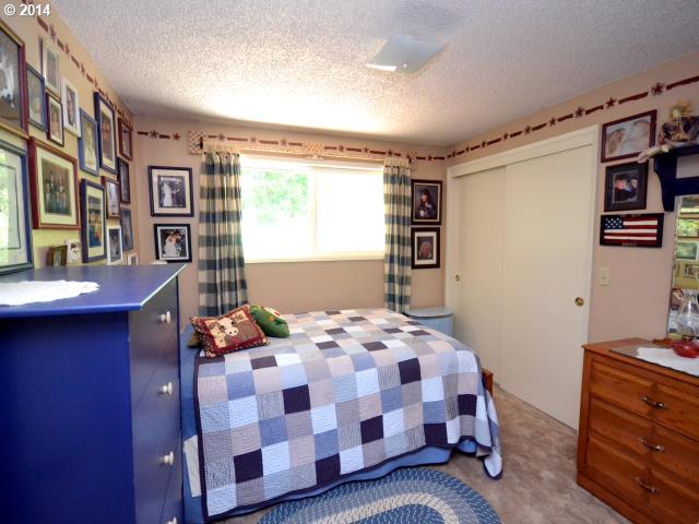 22871 South Reid Road Estacada, OR 97023 - Photo 7 of 16 a bedroom with a bed and wooden floor