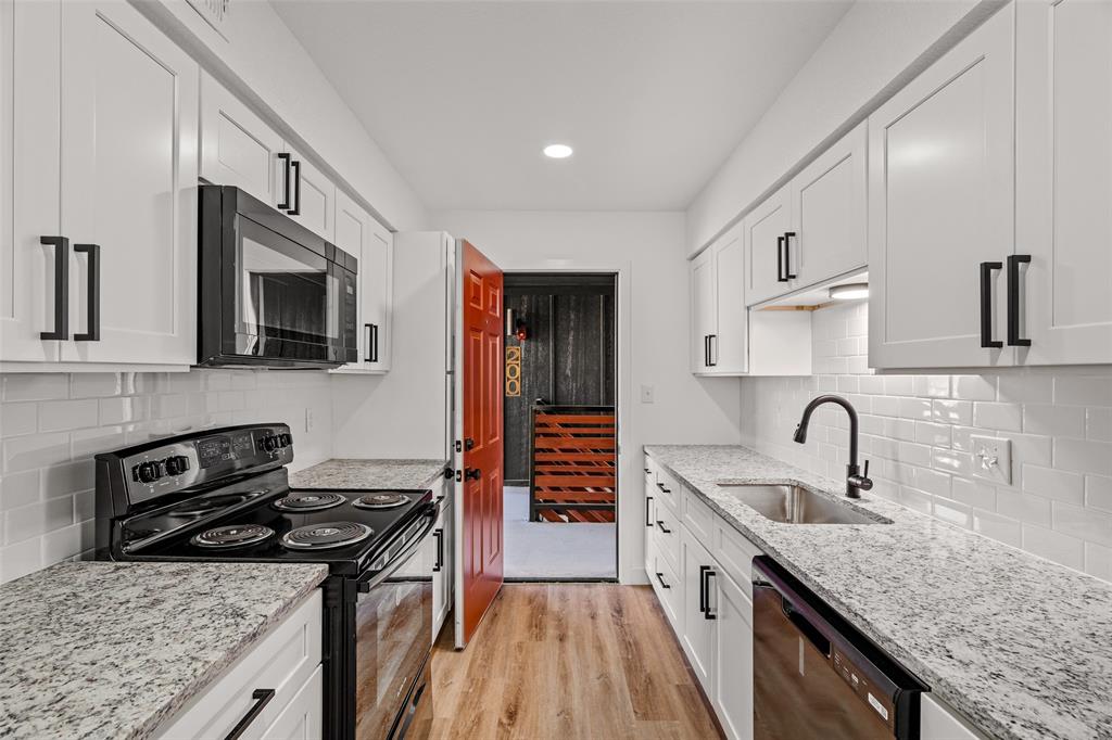 125 13th Street Southeast, Unit 201 Paris, TX 75460 - Photo 2 of 11 a kitchen with granite countertop kitchen island stainless steel appliances a sink stove top oven and cabinets