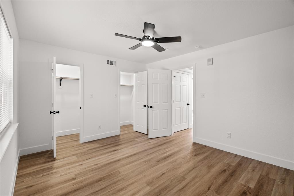 125 13th Street Southeast, Unit 201 Paris, TX 75460 - Photo 6 of 11 an empty room with wooden floor a ceiling fan and windows