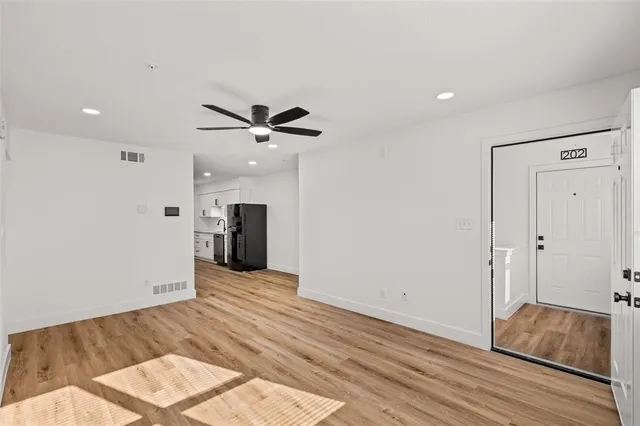 a view of a livingroom with wooden floor and a ceiling fan